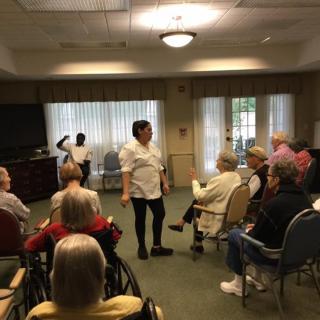 A person giving a presentation to an audience seated in a room.