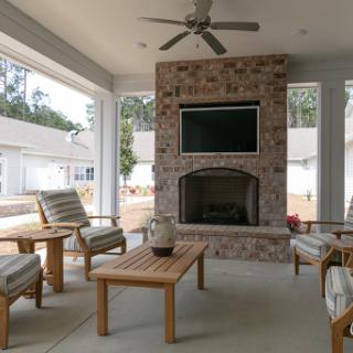 A cozy outdoor living space featuring a stone fireplace and comfortable seating.