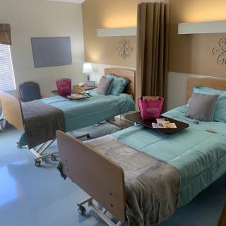 A clean and well-organized hospital room with two beds prepared for patients.