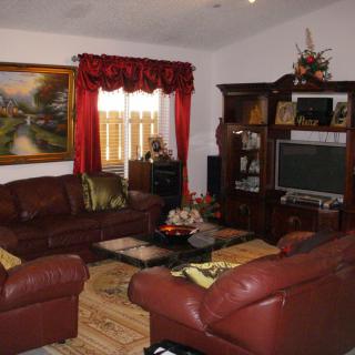 A cozy living room with brown leather sofas, a wooden coffee table, and a large entertainment center.