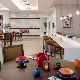 A modern dining room with colorful tableware and elegant lighting.