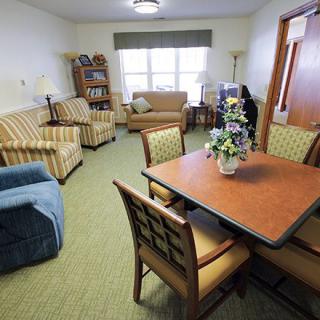 A cozy living room with various seating options and a central table.