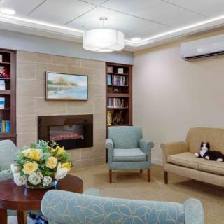 A cozy living room with a fireplace, bookshelves, and comfortable seating.