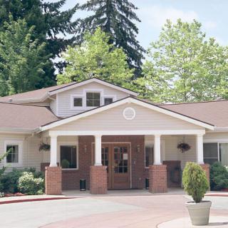 A residential building with a welcoming entrance surrounded by trees.