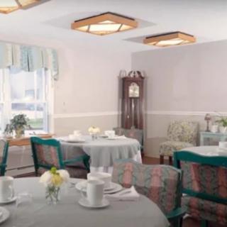 A cozy dining room with elegantly set tables, including a tea set and decorative elements.