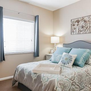 A cozy bedroom with a neatly made bed, soft pillows, and gentle lighting.