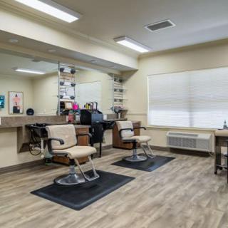 A well-lit barber shop interior with two haircut stations and mirrors.