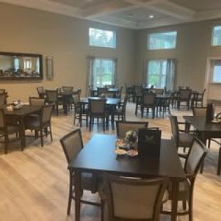 An empty dining room with neatly arranged tables and chairs.