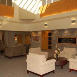 A modern lobby interior with comfortable seating and natural lighting from a skylight.