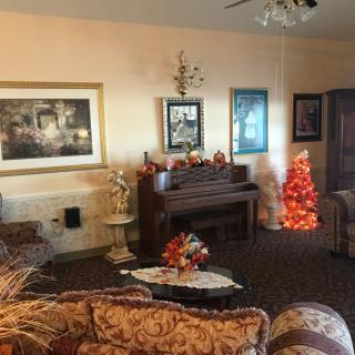 A cozy living room adorned with a piano, holiday decorations, and elegant furniture.