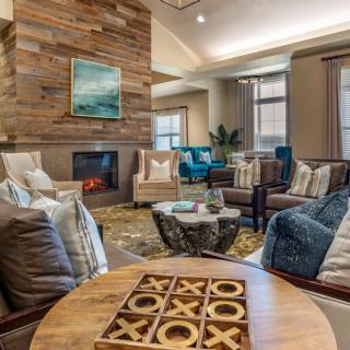 A cozy and modern living room with a fireplace, stylish furniture, and decorative elements.