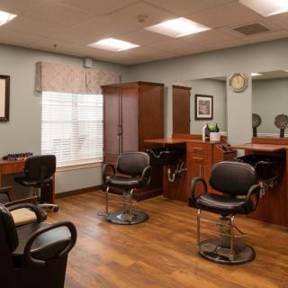 An interior view of a hair salon with styling chairs and mirrors in a neat arrangement.