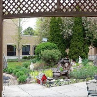 A serene garden featuring a water fountain and lush greenery, perfect for relaxation.