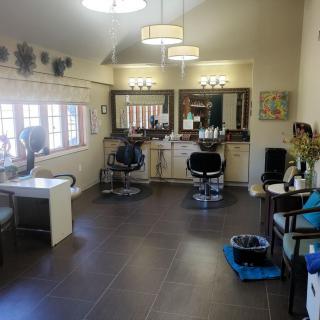 Spacious salon interior with styling stations and large windows.