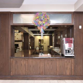 A coffee counter with wood paneling, decorated with balloons.