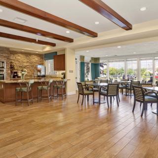 A modern dining area with wooden flooring, showcasing an open and inviting space with ample natural light.