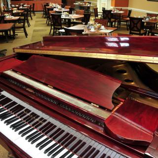 A grand piano in the dining area of a restaurant.