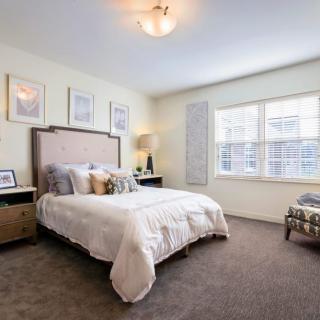 A cozy and well-decorated bedroom with large windows and elegant furnishings.