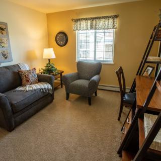 Cozy living room with a sofa, armchair, and warm lighting.