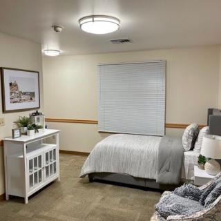 A tidy, minimalist bedroom with a single bed, nightstand, and decor.