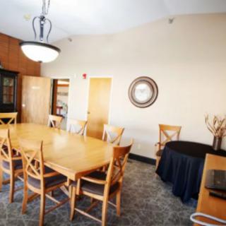 A well-furnished dining room with a wooden table, chairs, and a chandelier.