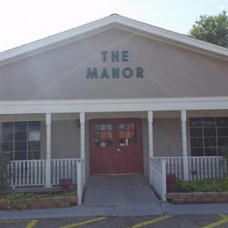 A charming view of The Manor, showcasing its inviting exterior and welcoming entrance.