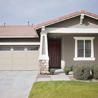 A suburban single-story house with a garage and front yard.
