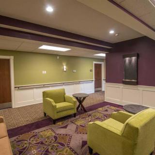 A cozy lounge area with green chairs and vibrant decor.