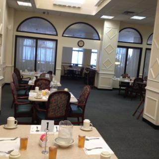 An elegantly set dining area with multiple tables and chairs, ready for guests.