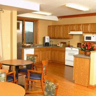 A modern kitchen and dining area with wooden cabinets and furniture.