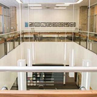 A view of a modern interior with glass walls and a staircase.