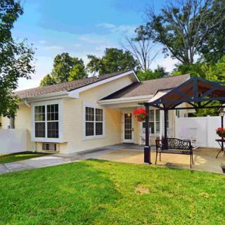 A cozy house with a well-maintained lawn and a patio area on a sunny day.