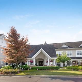 A picturesque residential building with well-maintained landscaping and clear blue sky.