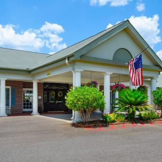 A building with a grand entrance, featuring columns and an American flag.