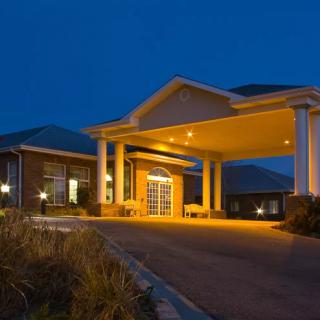 A well-lit hotel entrance at night, showcasing its architectural design.