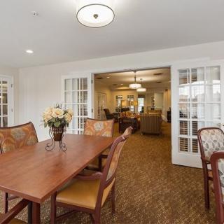 A well-decorated dining room with a wooden table and chairs, featuring elegant lighting and decorative elements.