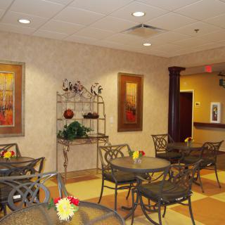 A cozy indoor seating area with decorative tables, chairs, and wall art.