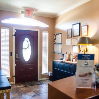A cozy waiting room with a front door and various decor elements.