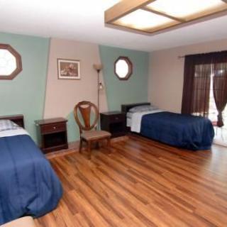 A spacious bedroom with two single beds and wood flooring.