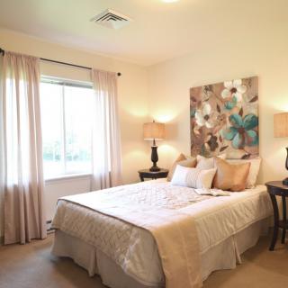 A cozy bedroom with soft lighting, a comfortable bed, and elegant decor.