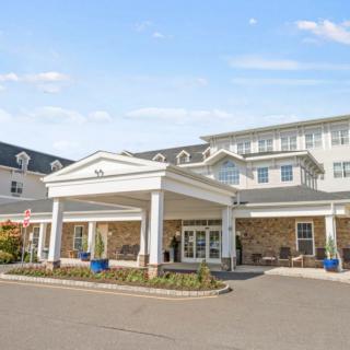 A large, welcoming hotel entrance with a covered driveway and bright exterior.