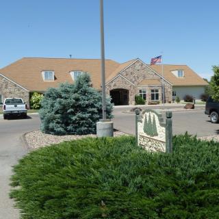 A residential building with a driveway and landscaped entrance, featuring a sign and an American flag.