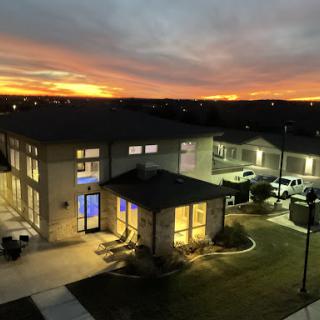 A serene sunset view over a modern building, highlighting the vibrant colors of the sky.