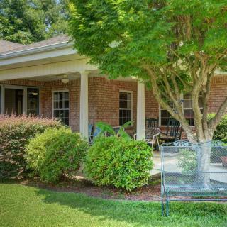A cozy brick house with a covered porch and well-maintained garden.