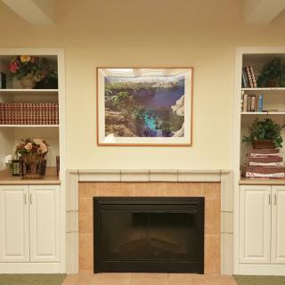 A cozy living room with a central fireplace flanked by built-in shelves adorned with books and decorative items.