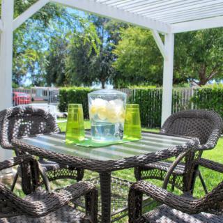 A sunny outdoor patio with wicker furniture and a table set for refreshments.