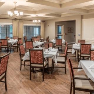 An empty dining room with neatly arranged tables and chairs.