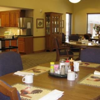 A cozy dining area with a table set for breakfast and an adjacent kitchen.