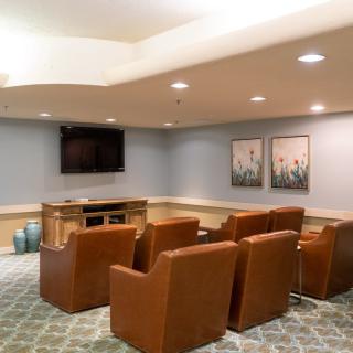 Cozy living room with comfortable armchairs facing a television, complemented by wall art.