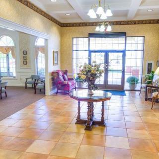 A bright and welcoming lobby area with elegant furniture and a central table adorned with flowers.